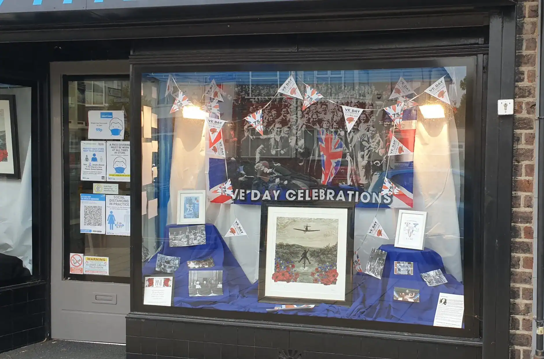 Romford shop window display celebrating UK national day with flags and artwork.